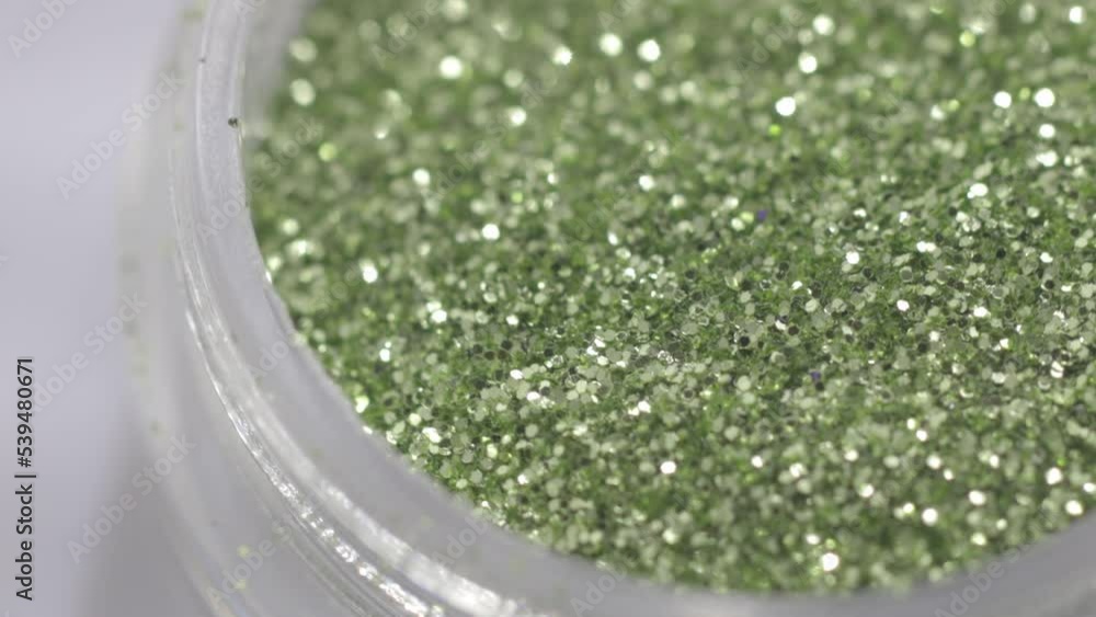 Poster green sequins in a jar rotate in a circle