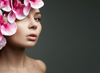 Beautiful Woman with Flowers Hat. Beauty Portrait of Girl with Orchid flower