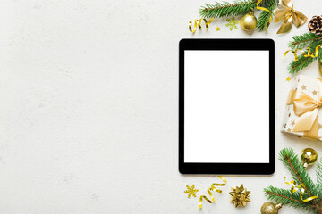 Digital tablet mock up with rustic Christmas decorations for app presentation top view with empty space for you design. Christmas online shopping concept. Tablet with copy space on colored background