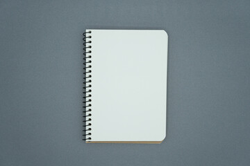 Blank notebook on grey background.
