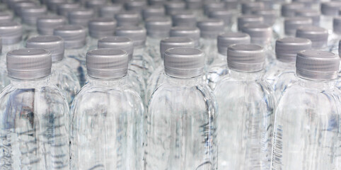 A large number of plastic bottled water products in a drinking water plant that are arranged in a row waiting to be sold to supermarkets. Beverage and drinking water business.
