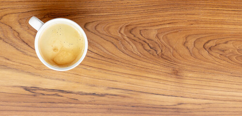 Top view of a coffee cup of americano on wooden background