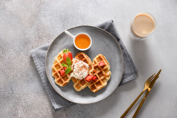 Breakfast with croffles and morning coffee on gray background. Croissant as waffle. View from above.
