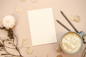 Autumn postcard card invitation muckup with latte and watercolor brushes on tan begie vertical background  with dry brown branches, transparent petals and white pumpkin candle.