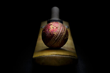 Red leather cricket ball on a cricket bat front view - 539485407