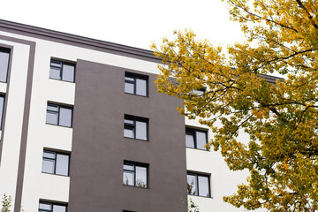 Modern residential building with new apartments and autumn tree