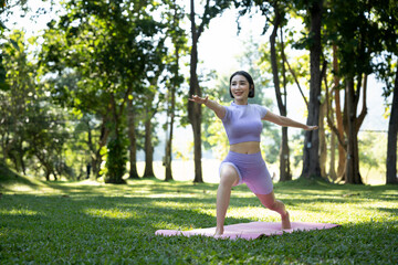 Fototapeta premium Portrait of a young woman doing yoga in the garden for a workout. Concept of lifestyle fitness and healthy. Asian women are practicing yoga in the park.