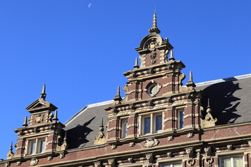 Fototapeta na wymiar Amsterdam Nieuwezijds Voorburgwal Ornate Historic Building Facade Detail with Blue Sky and Moon, Netherlands