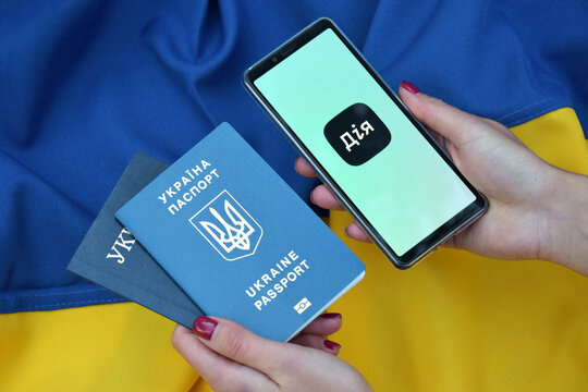 Diia application on the smartphone screen against the background of the flag of Ukraine.
