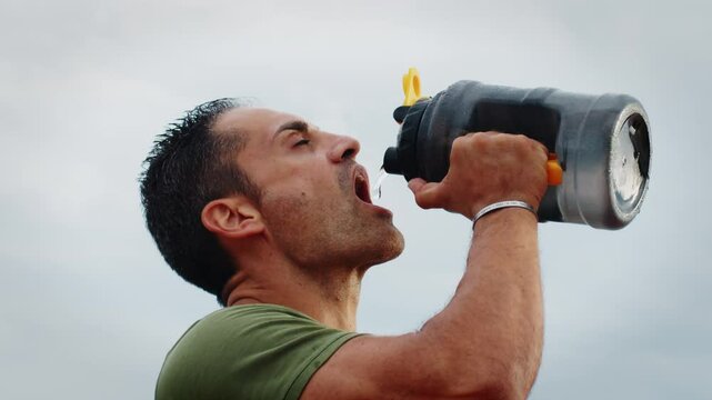 Athlete quenches his thirst with bottles of water