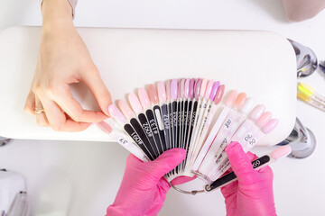 Fototapeta premium Professional manicurist showing colorful nail polish to check the finish result.