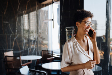 Middle-aged businesswoman talking on cellphone while working in office