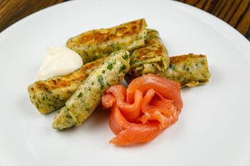 delicious pancakes with salted salmon on a plate.
