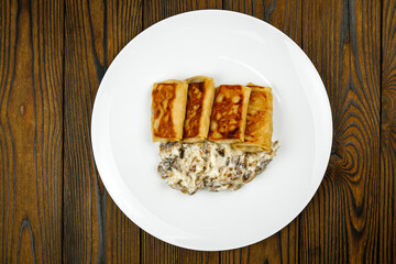 delicious pancakes with fried mushrooms on a plate.
