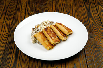 delicious pancakes with fried mushrooms on a plate.
