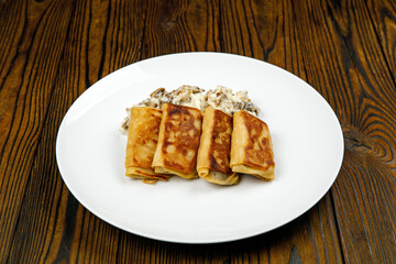 delicious pancakes with fried mushrooms on a plate.
