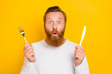 Photo portrait of handsome young man hold cutlery impressed new healthy diet wear stylish white...