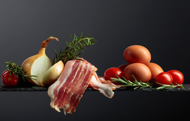 Smoked bacon with eggs, tomatoes, onions and rosemary.