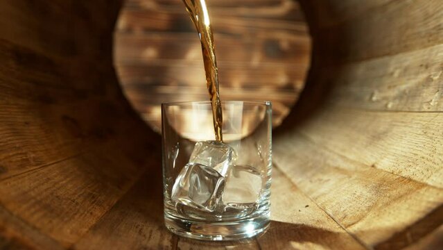 Super slow motion of pouring whisky into glass. Placed in old wooden keg. Filmed on high speed cinema camera, 1000fps.