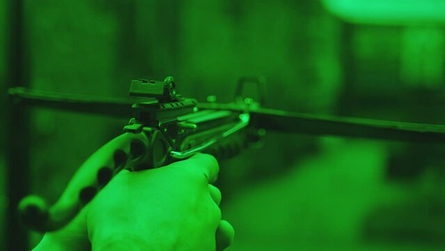 Firing a crossbow . Player or shooter loading arrow in arbalet and shooting to targets inside shooting range . Training practice or competition which requires great aiming accuracy and precision . 