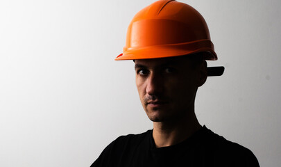 Confident young unshaven business man in light shirt protective construction helmet isolated on grey background. Achievement career wealth business concept. Mock up copy space.