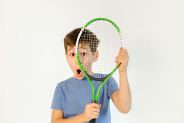 shocked funny boy in badminton rackets action on white background. children's badminton improves agility and quick reflexes, as well as coordination, balance and concentration