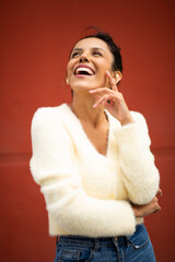 happy young latin woman laughing by red background