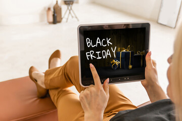 Woman using tablet pc and selecting black friday.