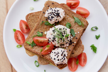 Vegan sandwiches with sourdough bread, tomatoes, herbs, quinoa and vegan sause. Top view