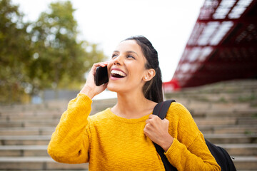 smiling woman talking with mobile phone and bag