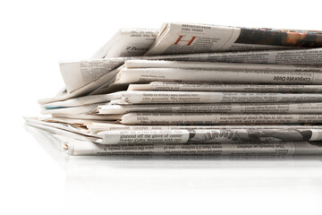 Pile of newspapers on white background, close up