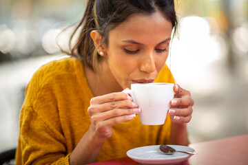 Close up young woman drinking cup of coffee