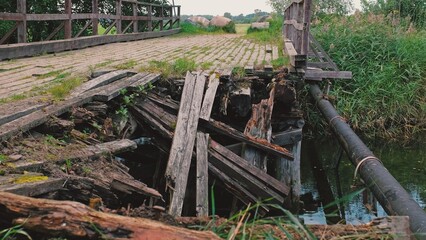 Damaged Collapsed Wooden River Bridge with Rotting Withered Beams