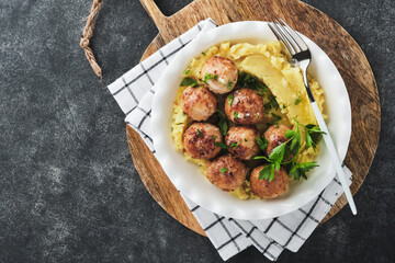 Swedish meatballs in cream sauce, potatoes and lingonberry sauce in bowl on slate, stone or...