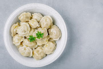 Dumplings. Meat stuffed Dumplings in a bowl on gray stone background.