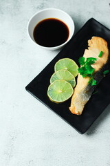 Salmon steak grilled with lemon served in Japanese style in a Japanese restaurant.