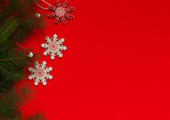 Three red white wooden snowflakes on a red background. Christmas nordic decor. Christmas wooden tree toys. Copy space.
