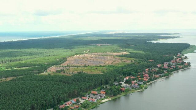 Drone footage of curonian spit and both sides can be seen, curonian lagoon and baltic sea, with little town Preila on the seaside