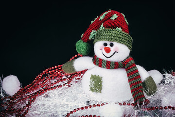 fun toy snowman and Christmas decorations on a black background