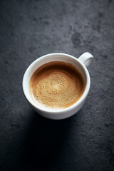 Cup of coffee on dark stone background. Close up. Copy space. 