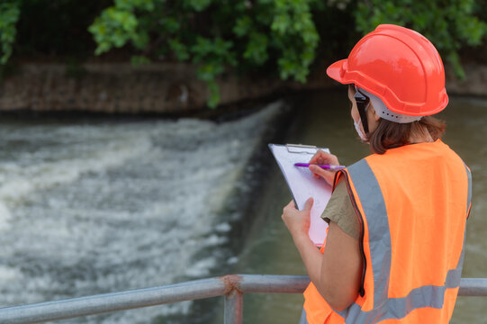 Asian Female engineering working . at sewage treatment plant,Marine biologist analysing water test results,World environment day concept
