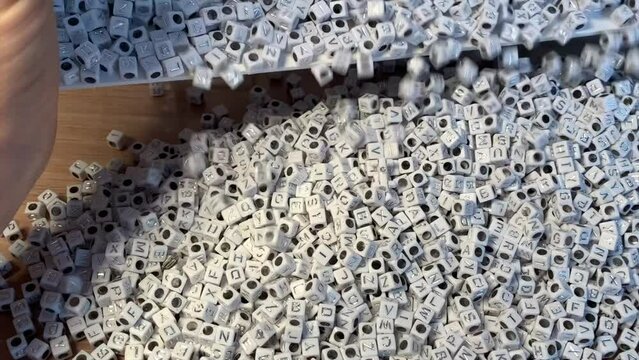 Versement des perles lettres de la bo&icirc;te sur la table. perles lettre pour cr&eacute;ation des bijoux accessoires 