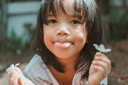 Cute Little Asian Girl Holding A White Bouquet. Child Planting Spring Flowers. 