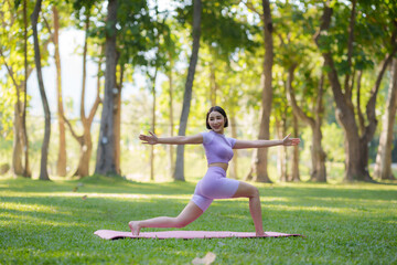 Obraz na płótnie Canvas Yoga in the park. Young Asian woman practicing yoga pose at the park.