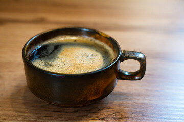 A cup of fragrant fresh coffe on wooden table at cafe. Close-up. Selective focus.