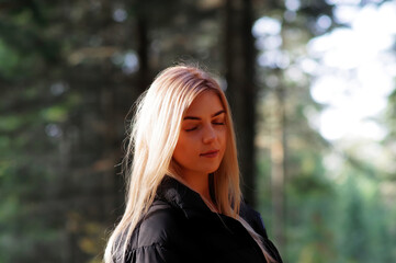Blond kobieta w lesie jesienią z zamkniętymi oczami. - obrazy, fototapety, plakaty