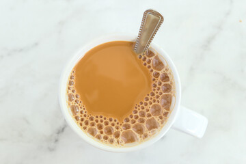Obraz na płótnie Canvas close up of cup of milk tea on table 