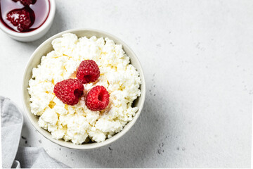 Cottage cheese breakfast bowl with cream and raspberries. Top view, flat lay, copy space.