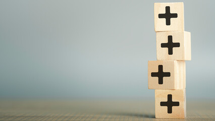 Plus sign in wooden cube block stacking. Addition and positive mindset thinking  such as profit,...