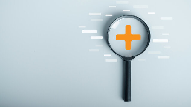 Magnifying glass focus on Plus sign and minus sign around. Addition and positive mindset thinking  such as profit, benefits, development, CSR represented, motivation, increase concept and copy space.